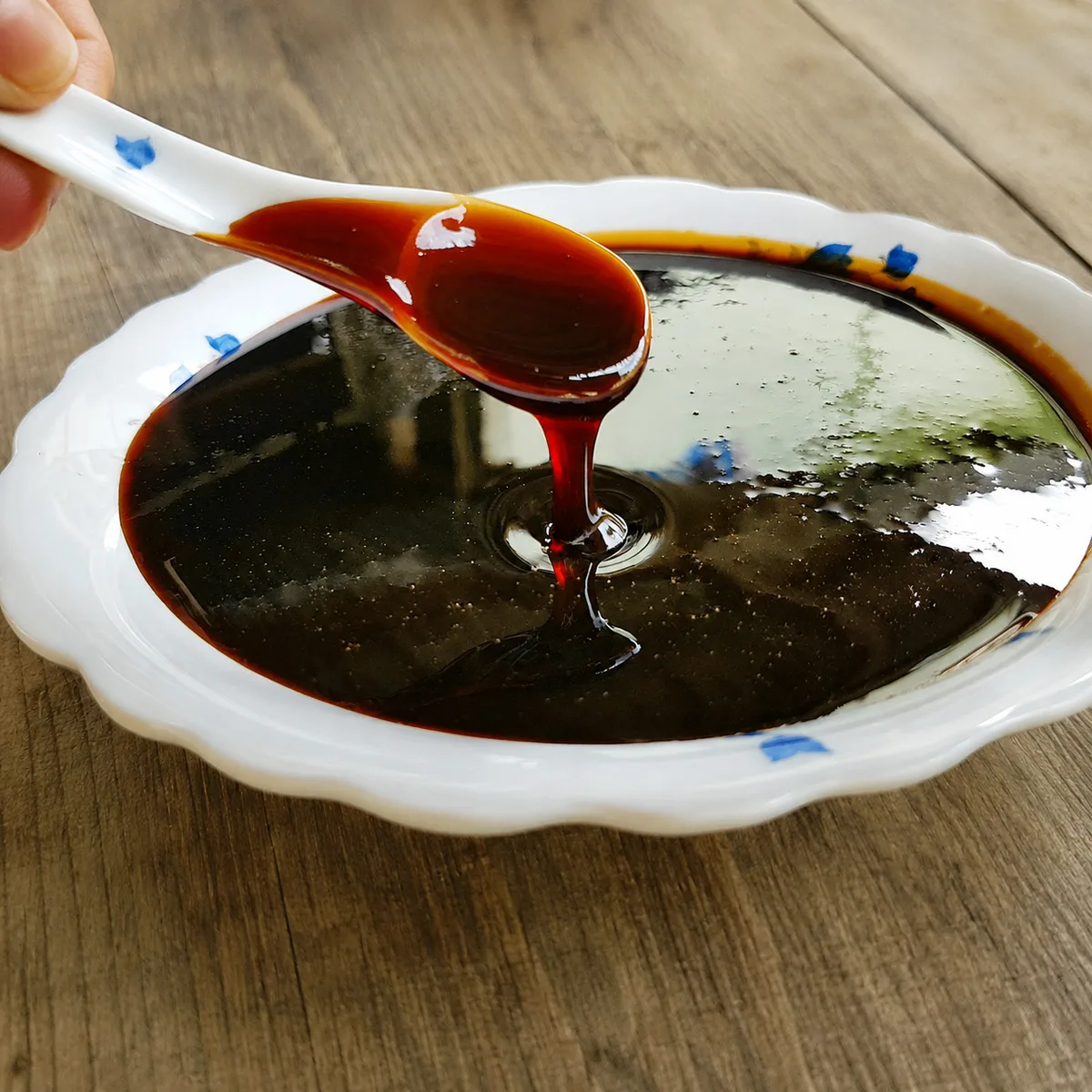 Traditionell mörk sirap på porslinsfat